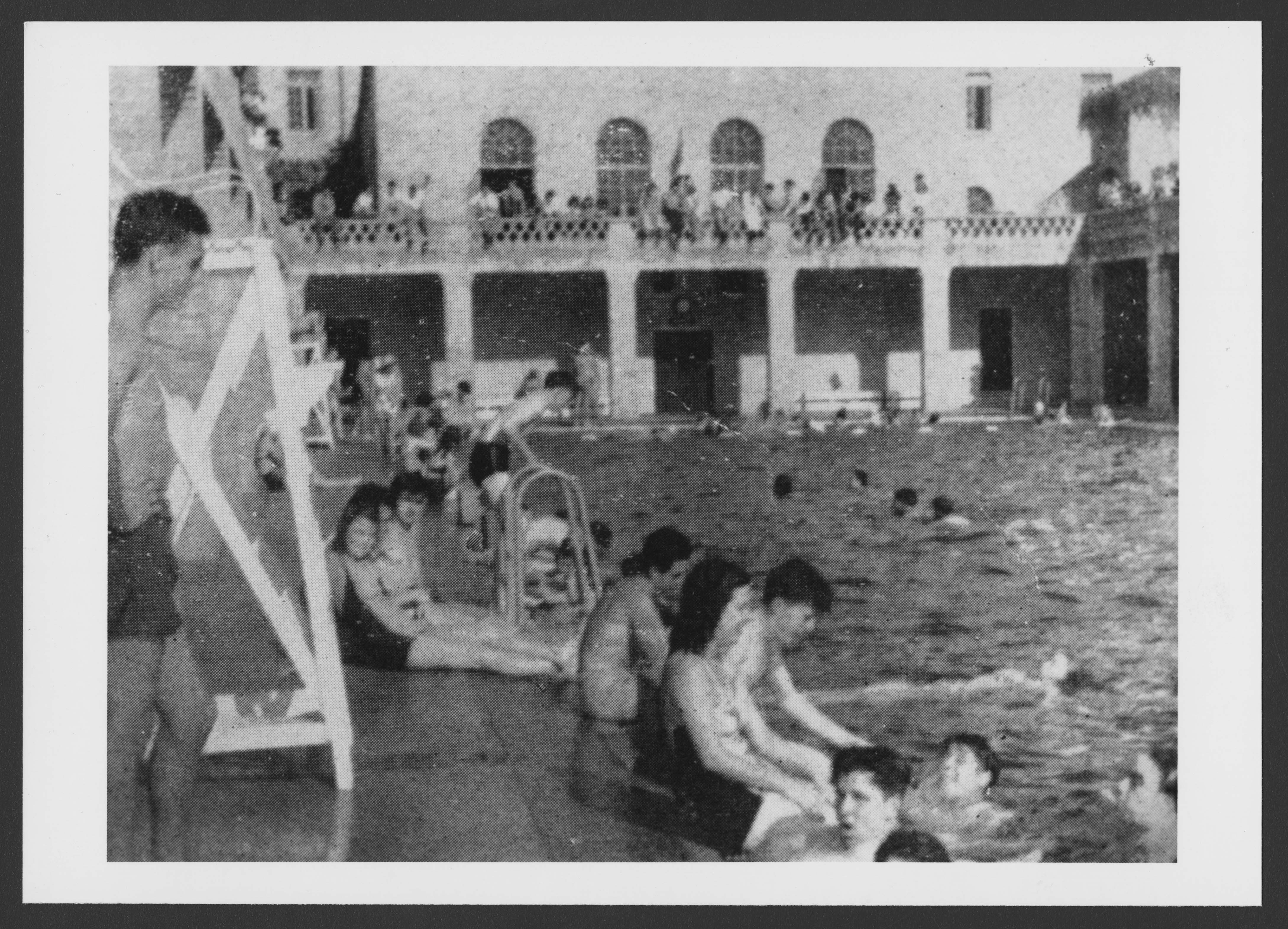 Scan of archive photo showing students enjoying the pool area.