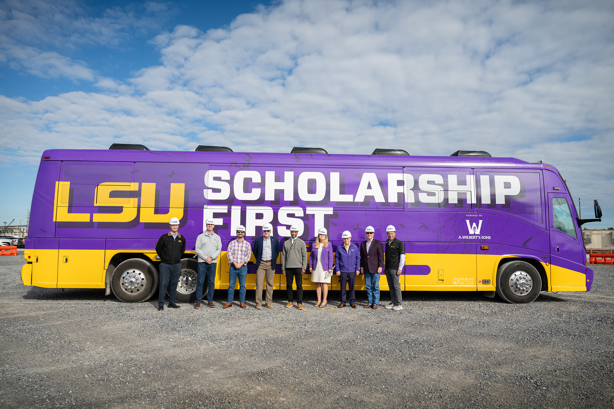 Performance Contractors employees stand in front of Scholarship First Bus