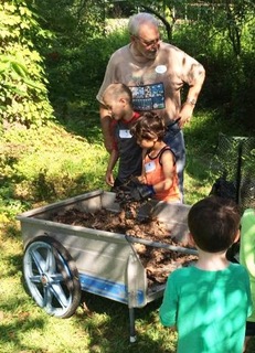 Bob Dillemuth giving a composting demonstration to children